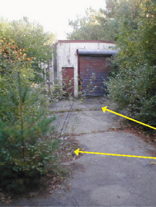 Building L-11 & Fueling Area.  View to South.  Arrows point to Concrete berm (top) & Drywell.